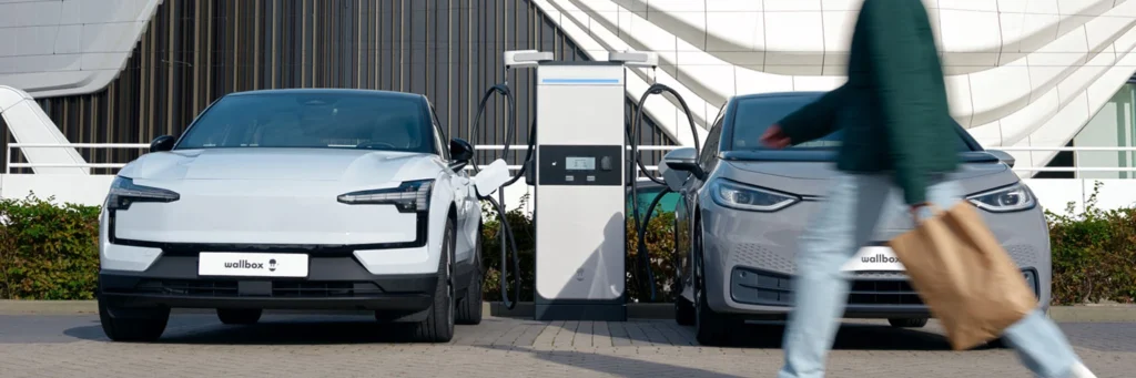 Elektromos autó gyorstöltő állomás két elektromos autóval, wallbox DC gyorstöltővel, type 2 csatlakozóval és gyors töltéssel.