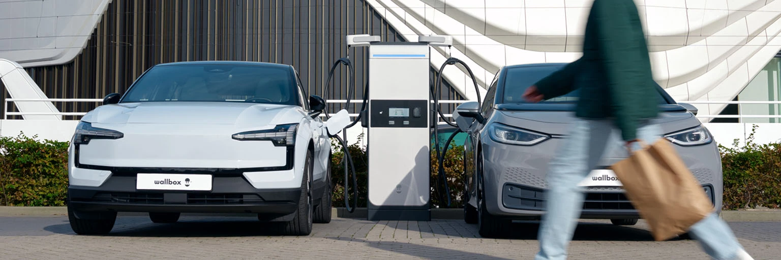 Elektromos autó gyorstöltő állomás két elektromos autóval, wallbox DC gyorstöltővel, type 2 csatlakozóval és gyors töltéssel.