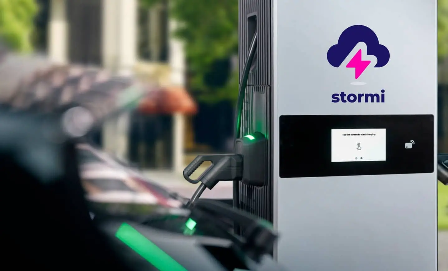Stormi elektromos autó töltő használat közben, publikus fizetős töltőállomás kWh alapú számlázással.